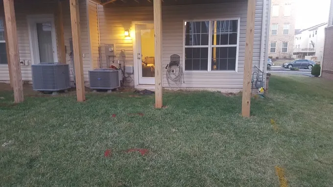 small backyard with deck posts and grass