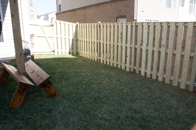small backyard with deck posts and grass