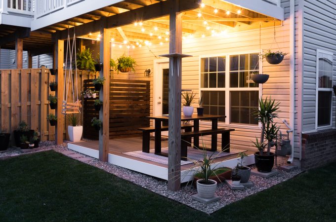Modern design ideas for a small backyard // DIY rock landscaping around a gray Trex platform deck // Hanging herbs // DIY outdoor cat perches // DIY HVAC unit screen // small garden ideas // hanging ferns on a patio // hanging globe string lights