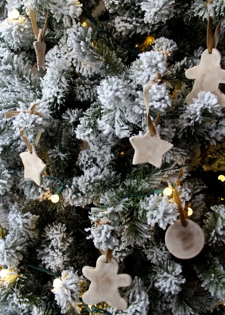 Salt dough ornaments hanging on a frosted Christmas tree