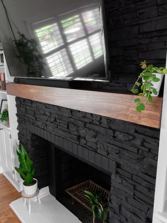 black painted fireplace with a wooden mantel shelf