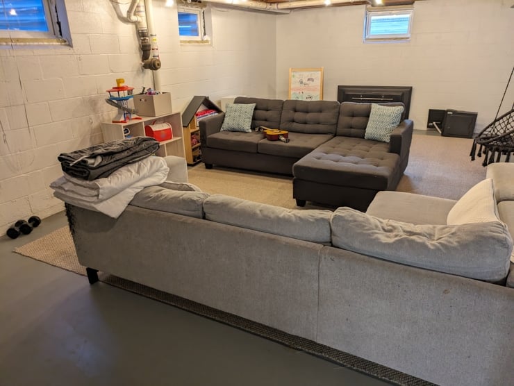 unfinished basement with couches and toys