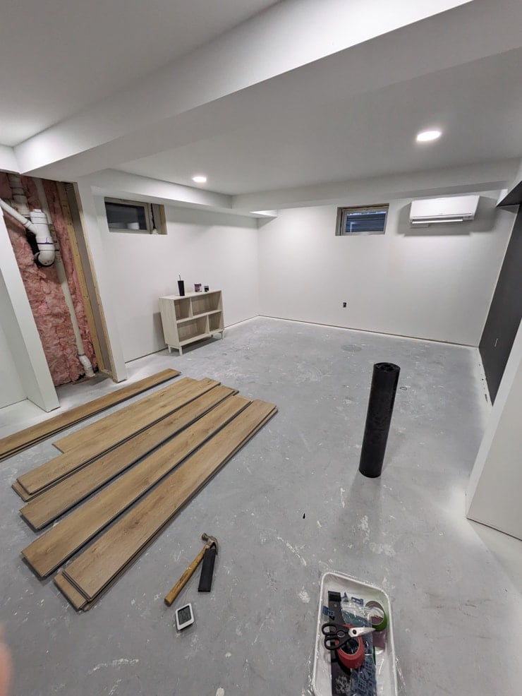 laying flooret vinyl plank flooring in a basement with a concrete sunfloor