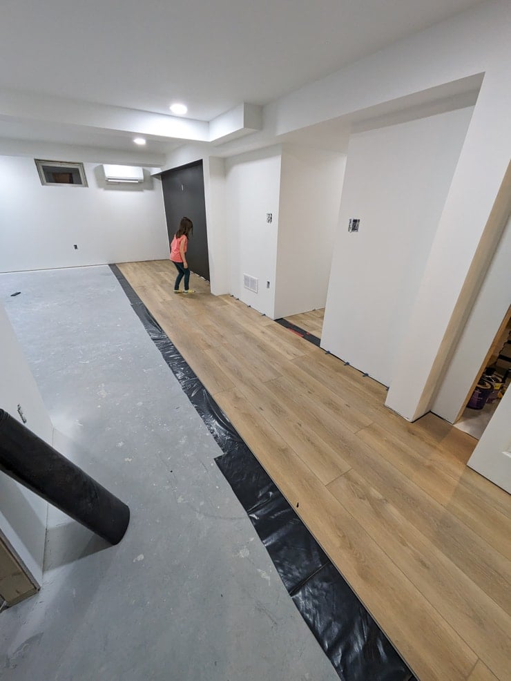 laying flooret modin nakan planks in a basement