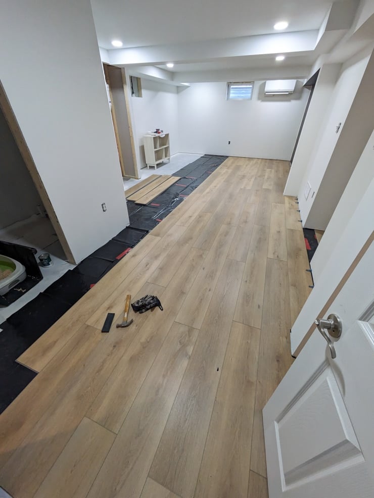 laying flooret modin nakan planks in a basement