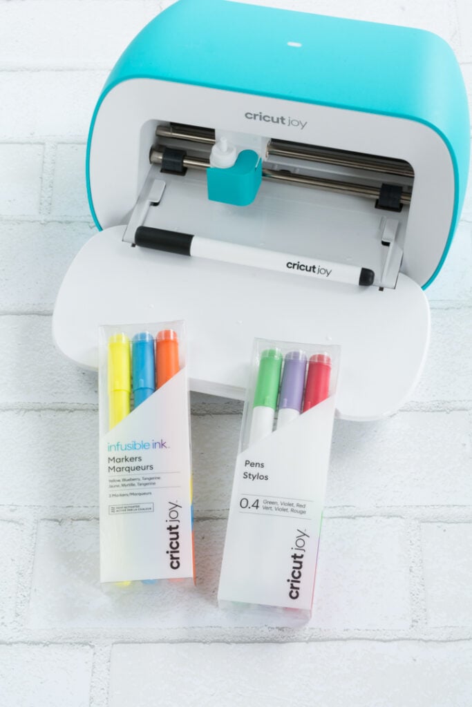 Cricut joy machine and pens in packages