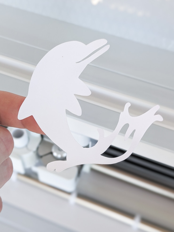 cutting dolphins out of sticker cardstock
