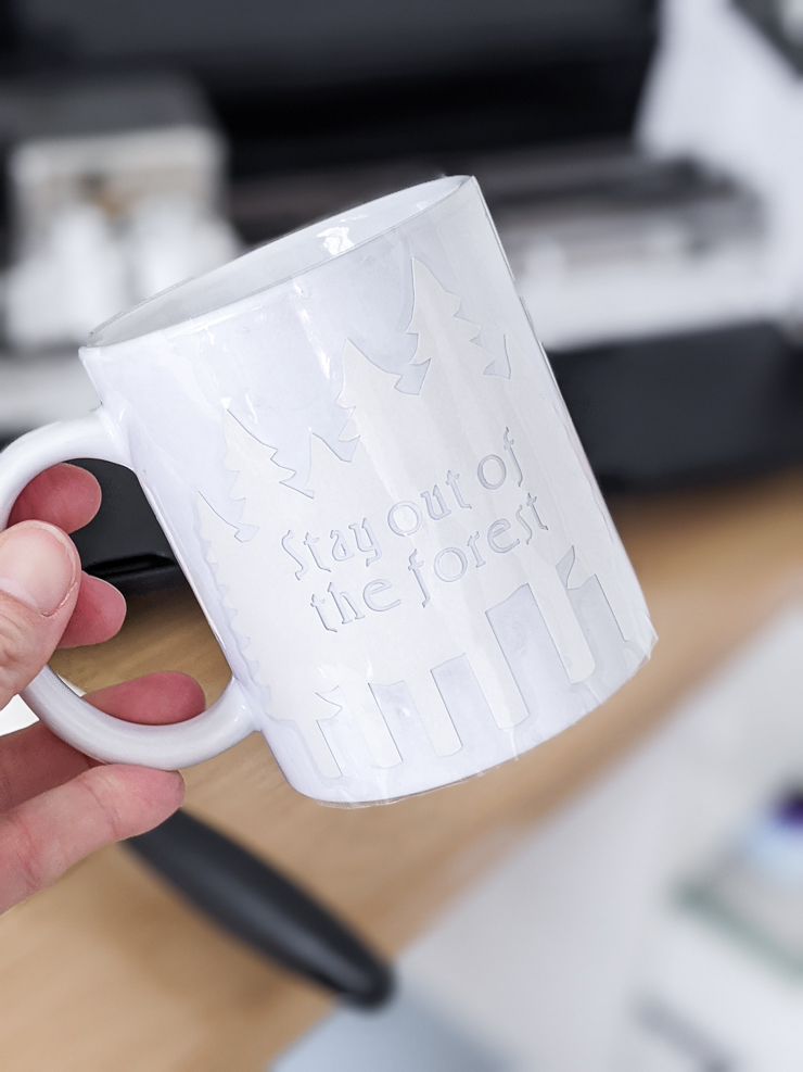 Infusible Ink transfer sheet on a mug that says "stay out of the forest"