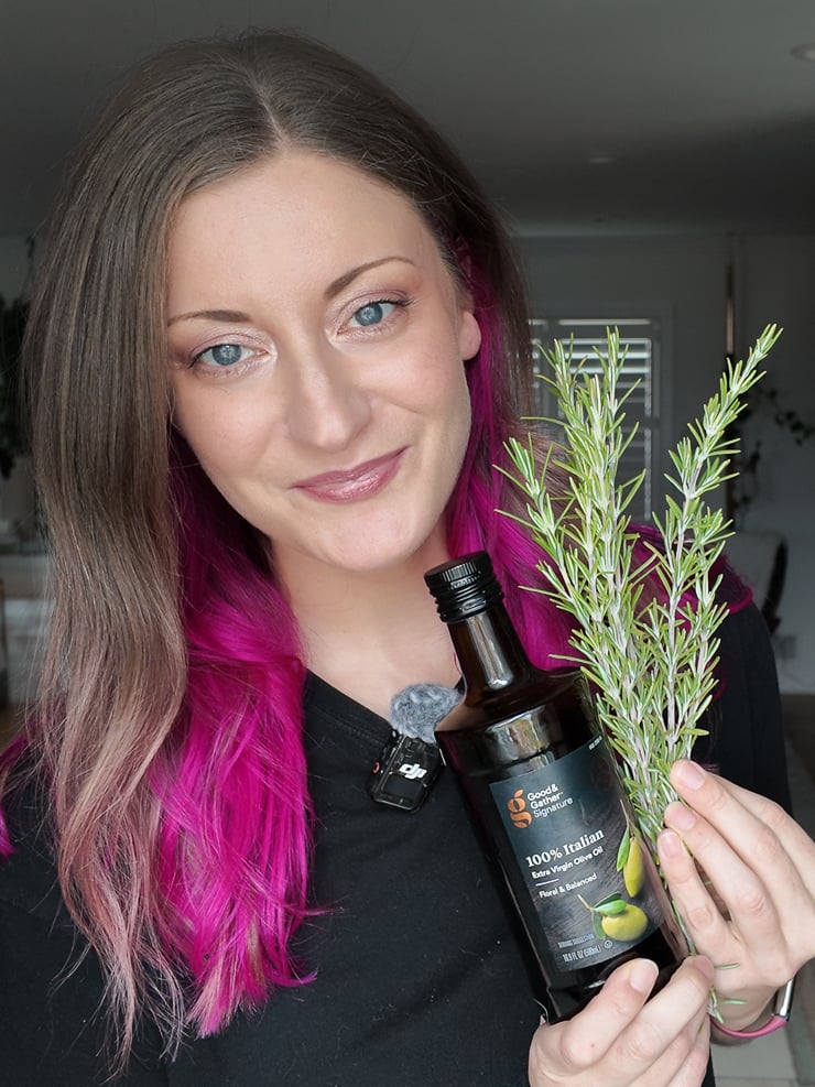 woman holding olive oil and rosemary