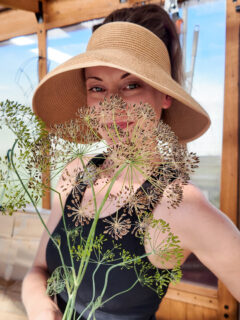 woman holding an umbel of dill seeds